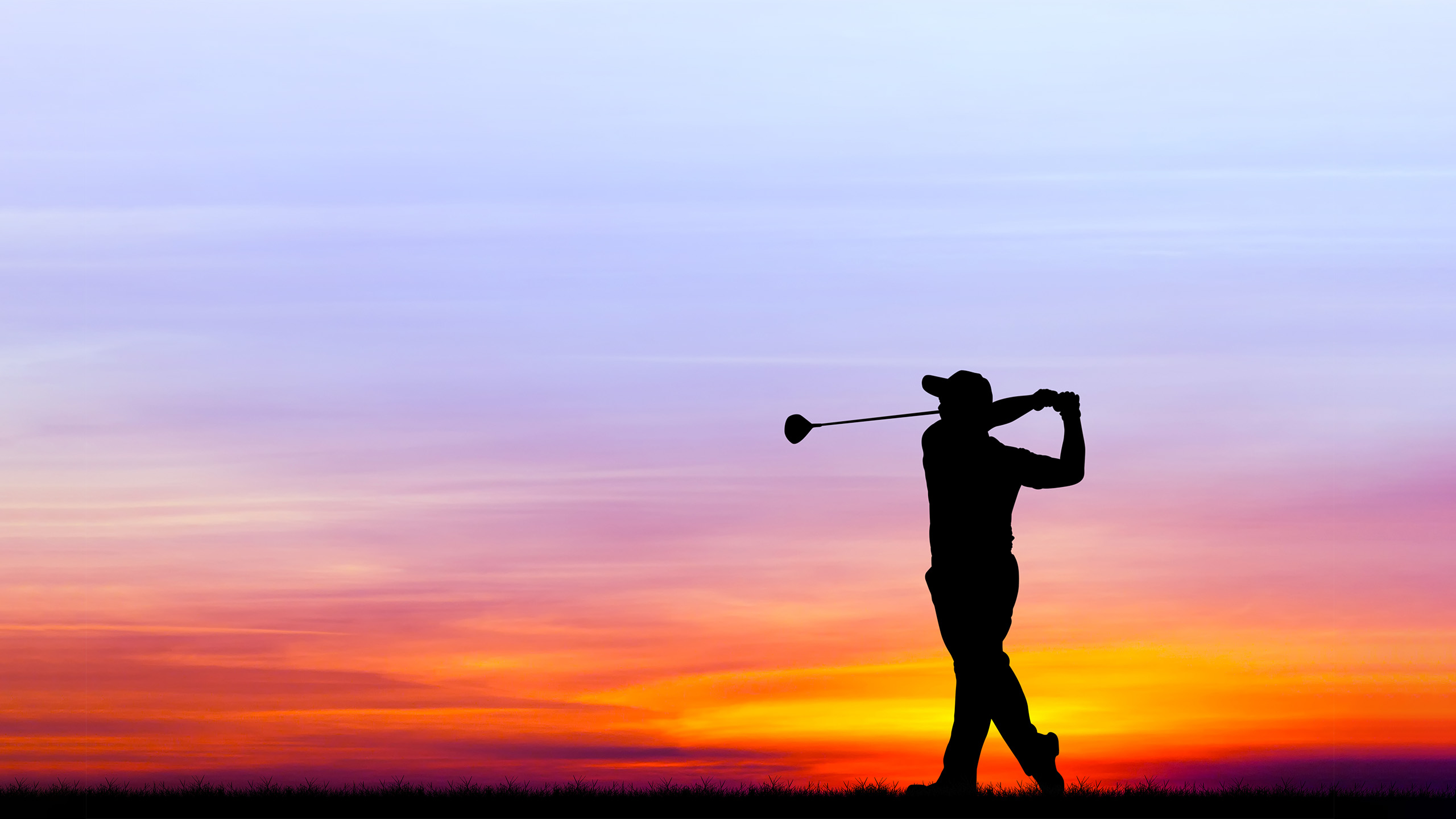Silhouette of golfer swinging at sunset