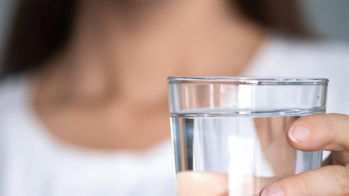 Person holding glass of water
